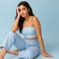Woman wearing a light blue floral top and pants against a light blue background