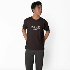 Person wearing a black 'RARE' t-shirt and dark pants on a white background