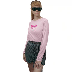Person wearing a pink long-sleeve shirt with 'ZONE OUT' text and black shorts on a white background