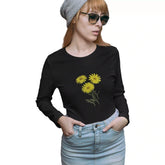 Person wearing a black long-sleeve shirt with yellow floral design on a white background