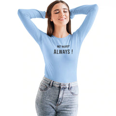 Woman wearing a light blue long-sleeve shirt with text, standing against a white background