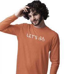 Man wearing an orange long-sleeve shirt with 'LET'S' and a bicycle graphic on a white background