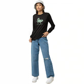 Person wearing a black long-sleeve shirt with a graphic design and blue jeans on a white background