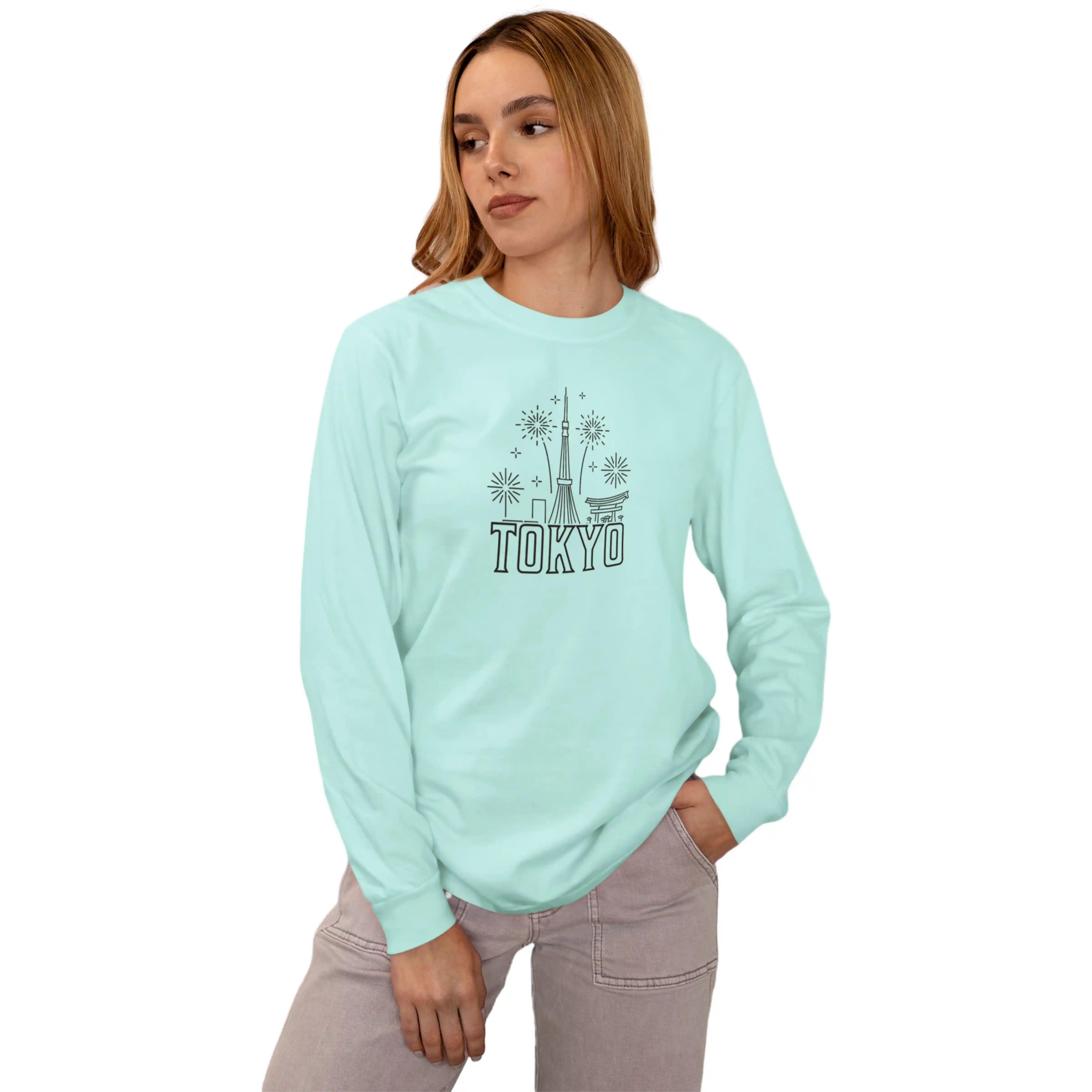 Person wearing a light blue sweatshirt with 'TOKYO' and a graphic design on a white background