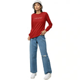 Person wearing a red long-sleeve shirt and blue jeans on a white background