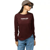 Person wearing a maroon long-sleeve shirt with 'Fearless no pause, no doubt' text on a white background