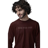 Man wearing a brown long-sleeve shirt with 'ARE YOU OK?' text on a white background