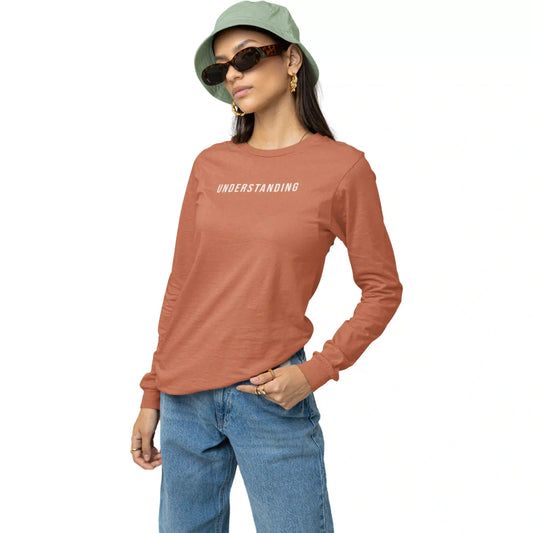 Person wearing a brown long-sleeve shirt with 'UNDERSTANDING' text, blue jeans, and a green bucket hat on a white background.