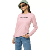 Person wearing a pink long-sleeve shirt with 'CALM DOWN' text, blue jeans, and a green bucket hat on a white background.