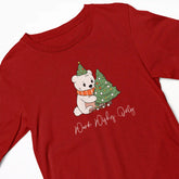 Red t-shirt with a Christmas-themed design of a polar bear and tree on a white background