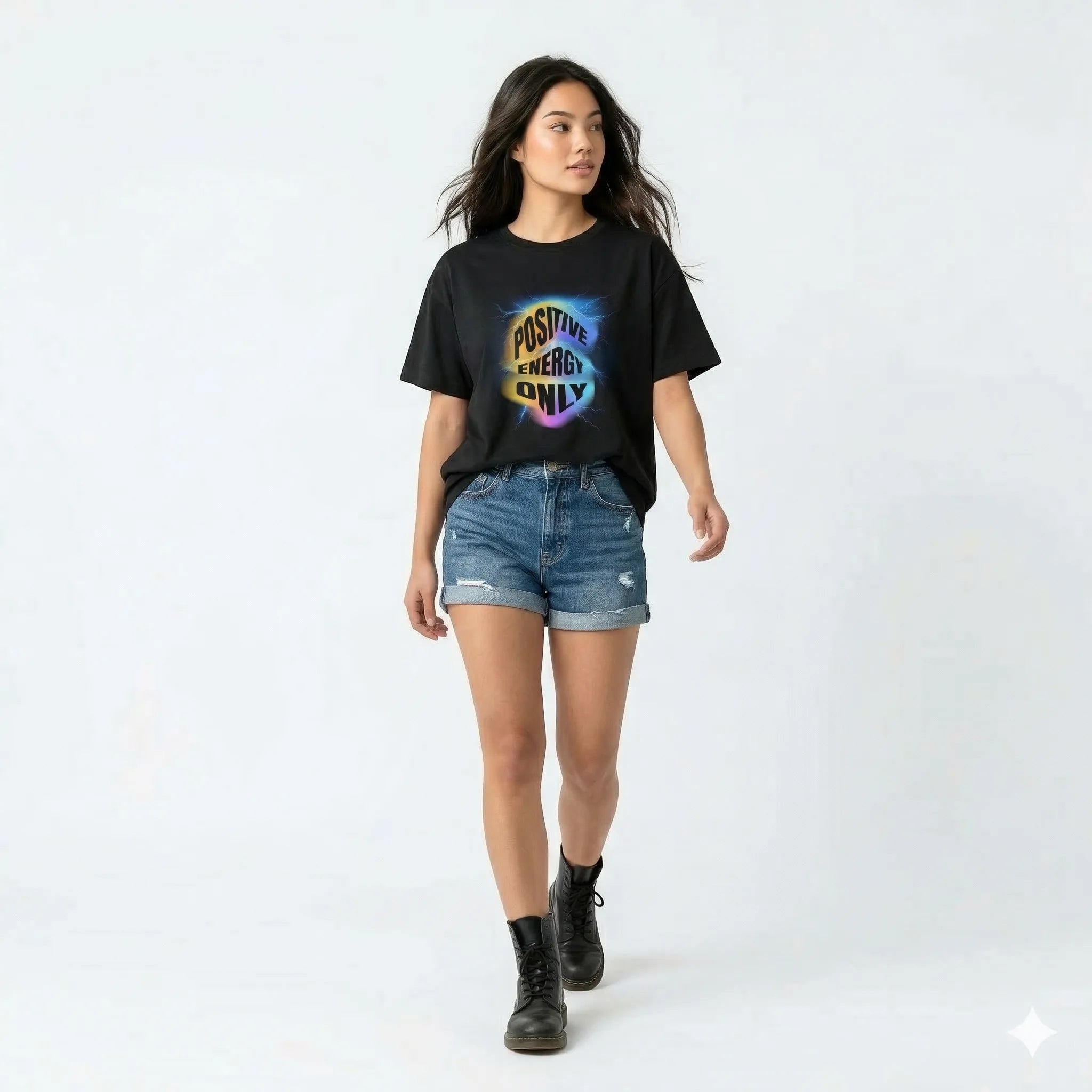 Black t-shirt with 'Positive Energy Only' design on a hanger against a white wall with plants.