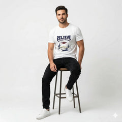 Man sitting on a stool wearing a white t-shirt with a graphic design and text.