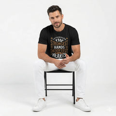 Man sitting on a chair wearing a black t-shirt with text, white pants, and white sneakers on a white background