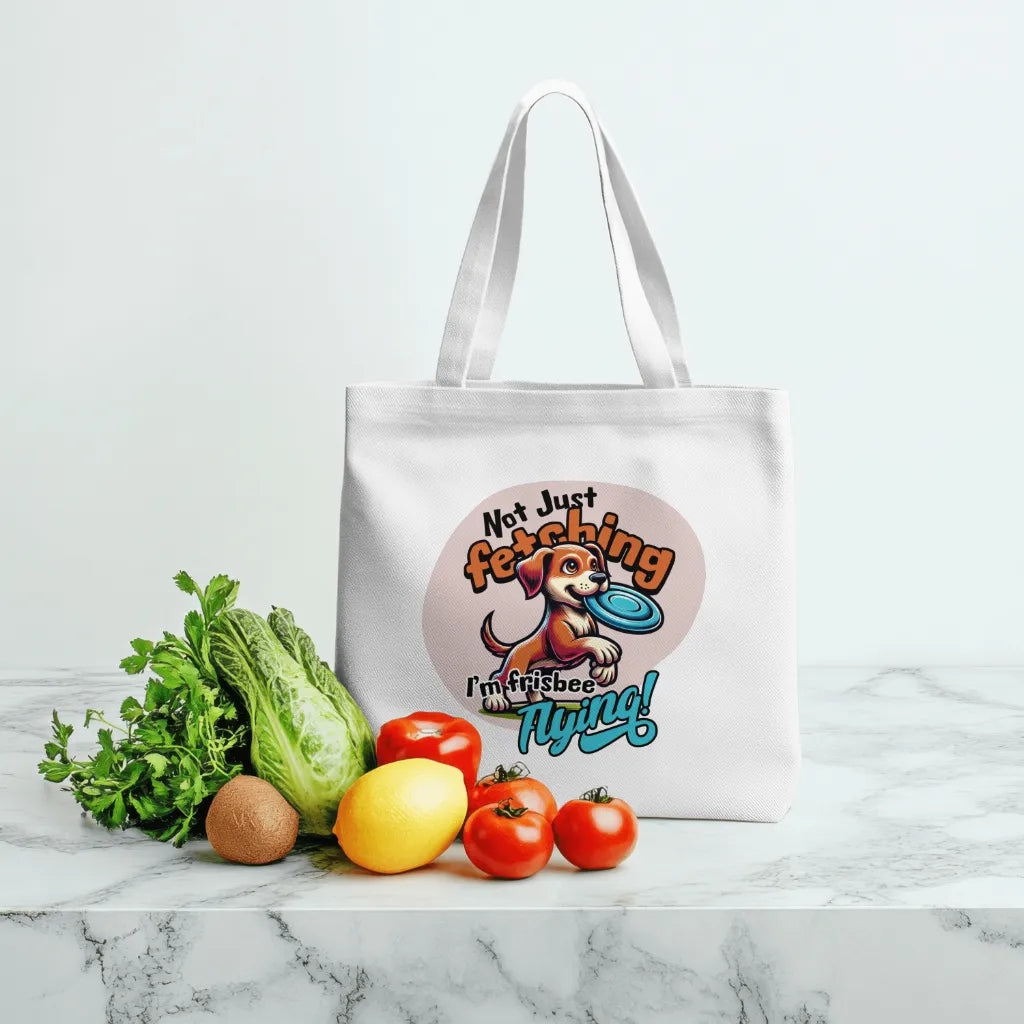 Tote bag with a dog graphic and text, surrounded by vegetables on a marble surface.