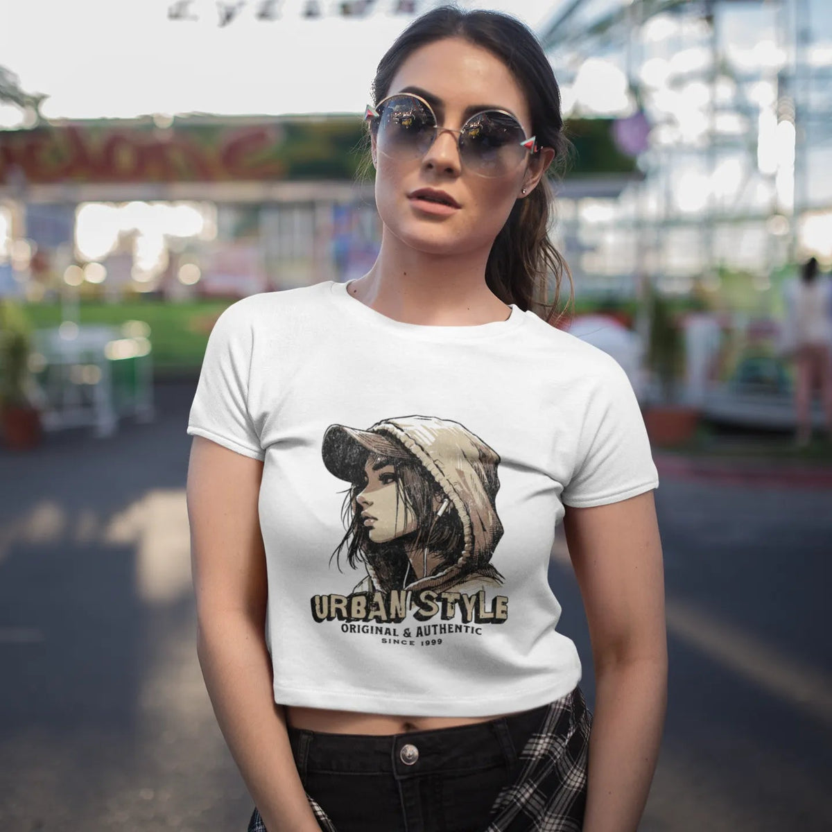 Woman wearing a white t-shirt with a graphic design at an amusement park.