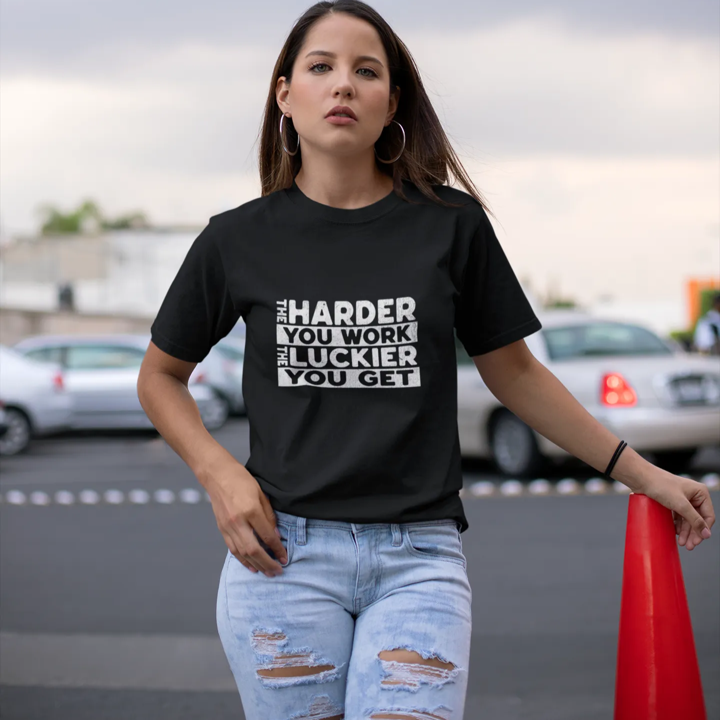 Woman wearing a black t-shirt with text in an outdoor setting
