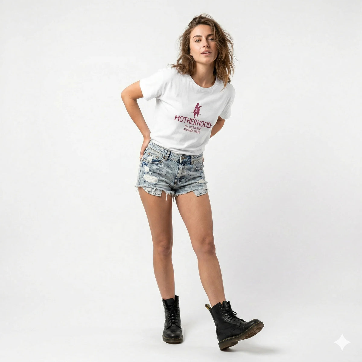Woman wearing a white t-shirt with a graphic and text, standing against a stone wall.