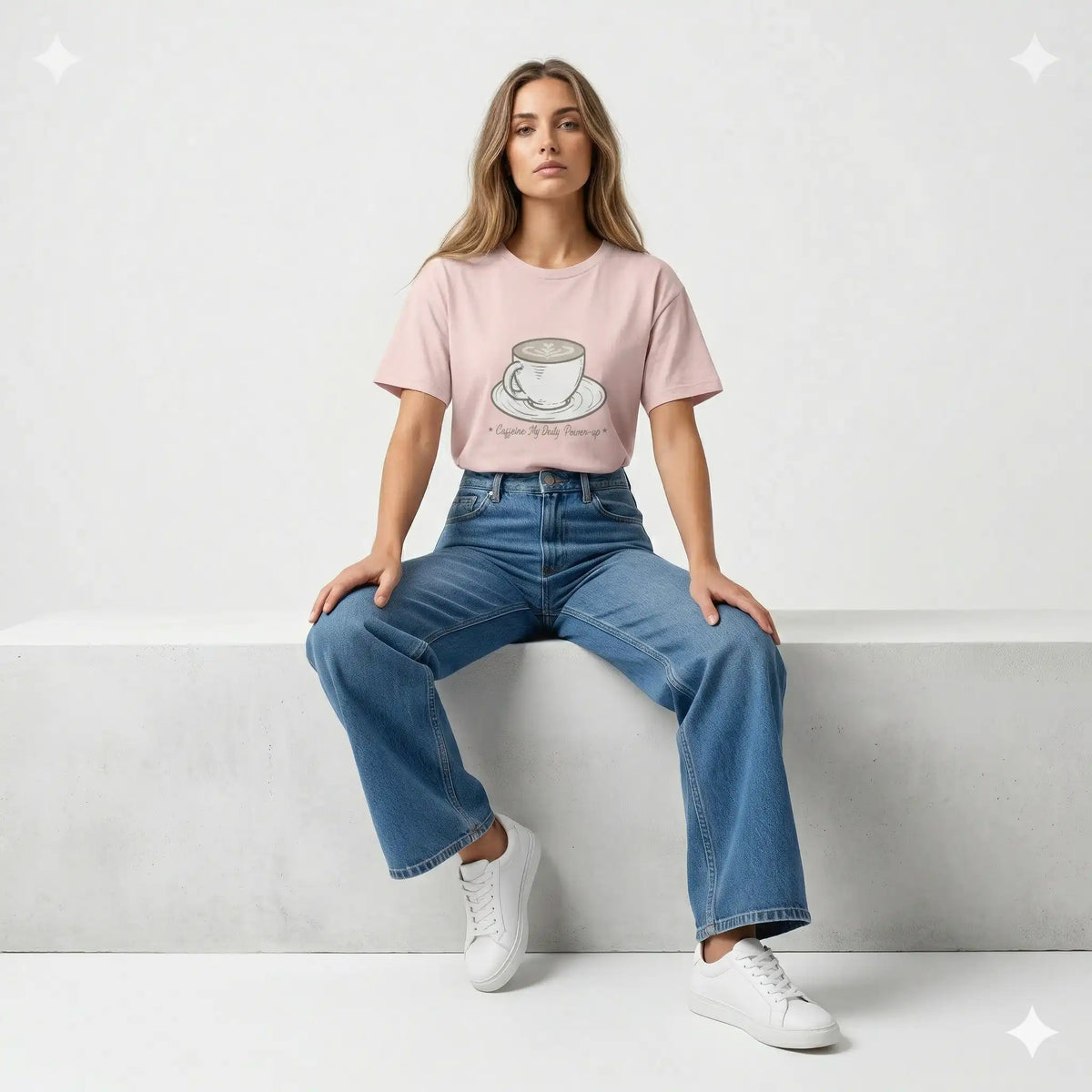 Woman wearing a pink t-shirt with a coffee cup design in a dimly lit room.