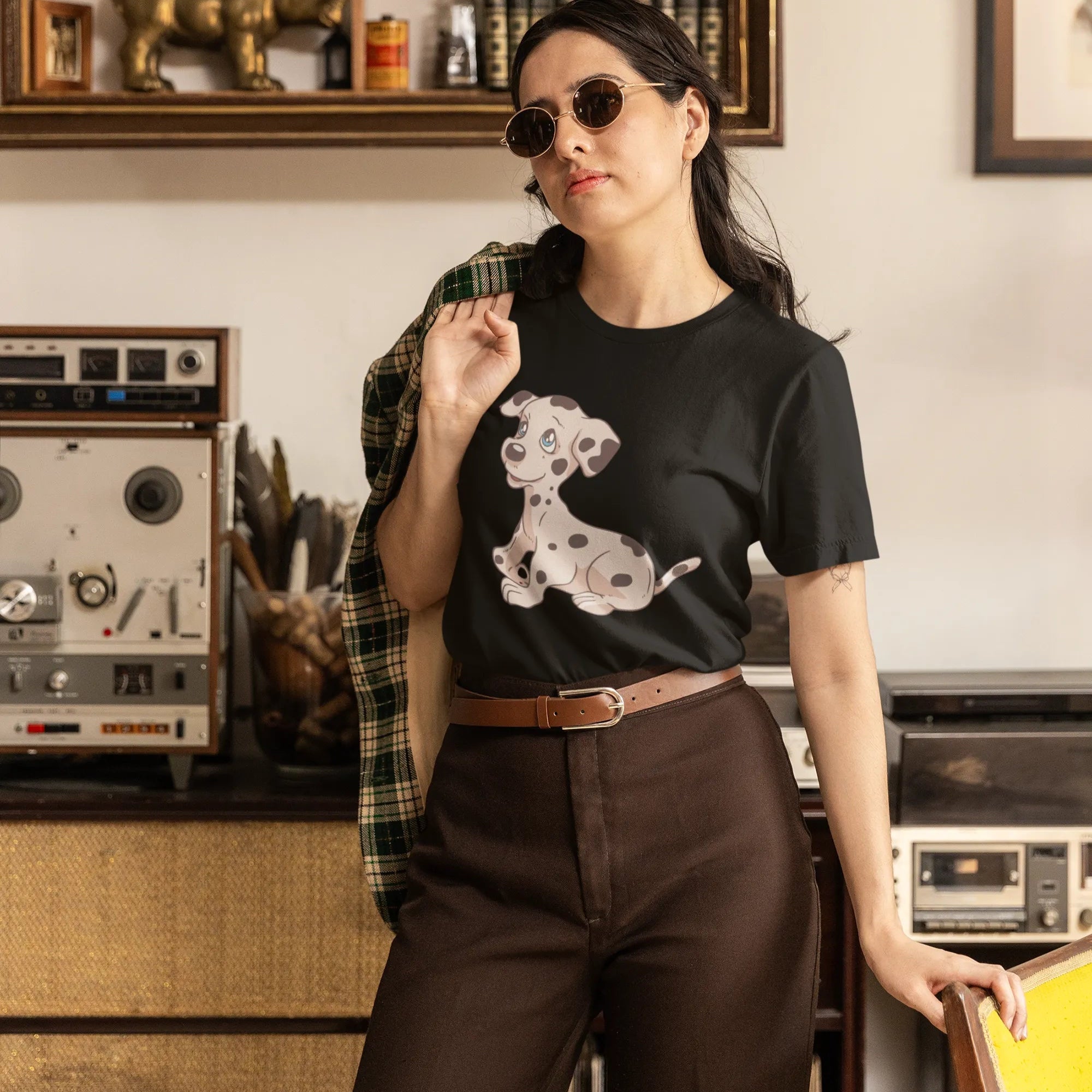 Woman wearing a black t-shirt with a graphic design in a room with vintage equipment.