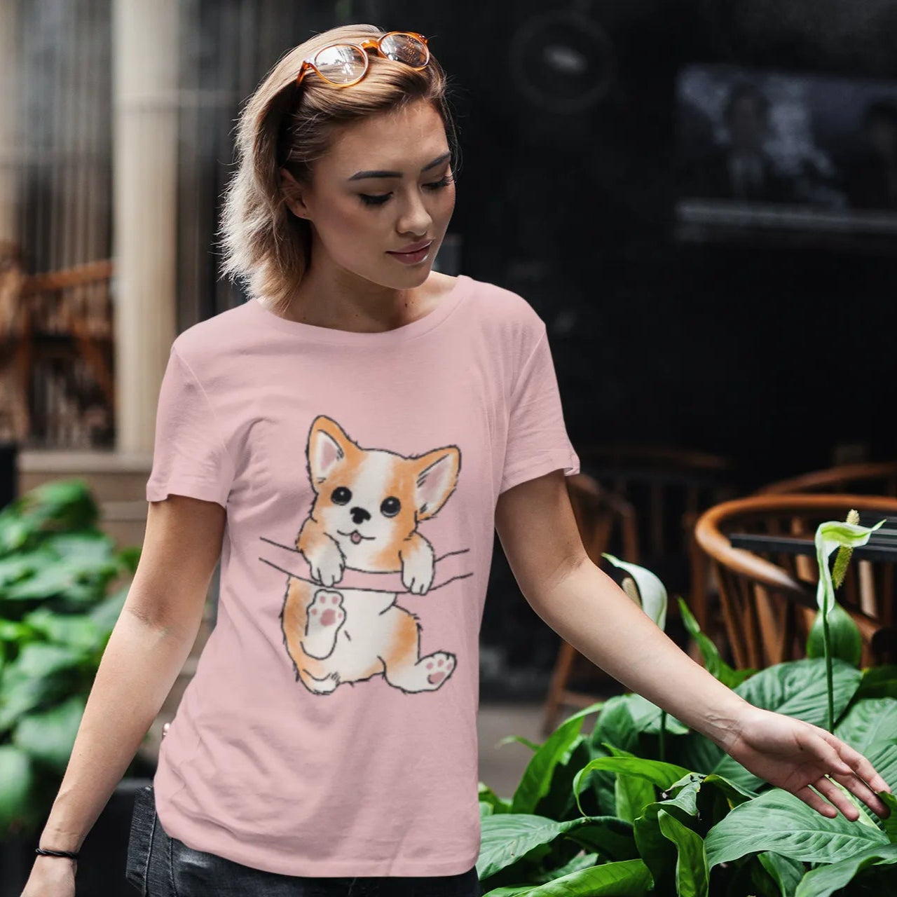 Woman wearing a pink t-shirt with a dog graphic in an outdoor setting
