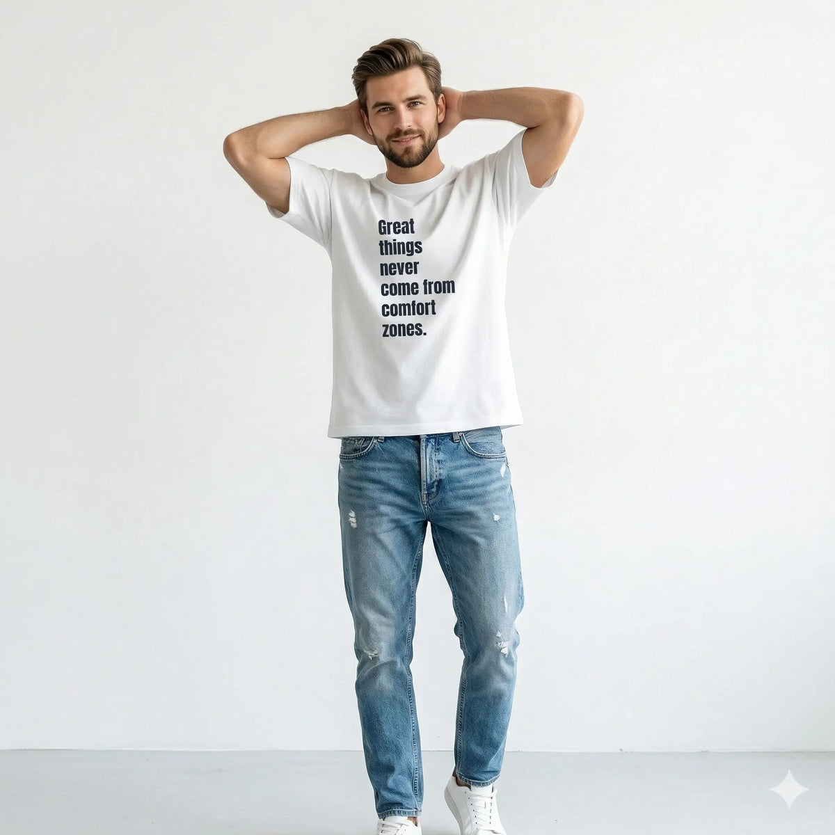 Man wearing a white t-shirt with a motivational quote and blue jeans on a light gray background