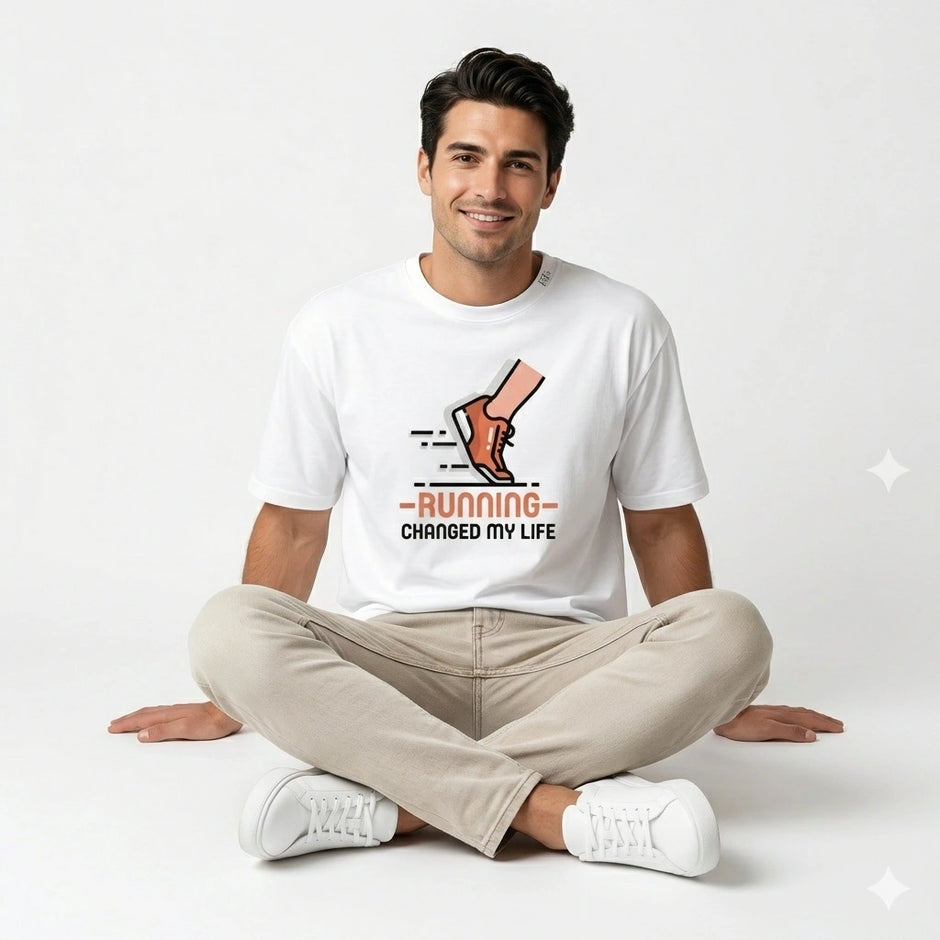 Man sitting cross-legged wearing a white t-shirt with a graphic and text.