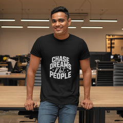 Man wearing a black t-shirt with 'Chase Dreams Not People' text in an office setting
