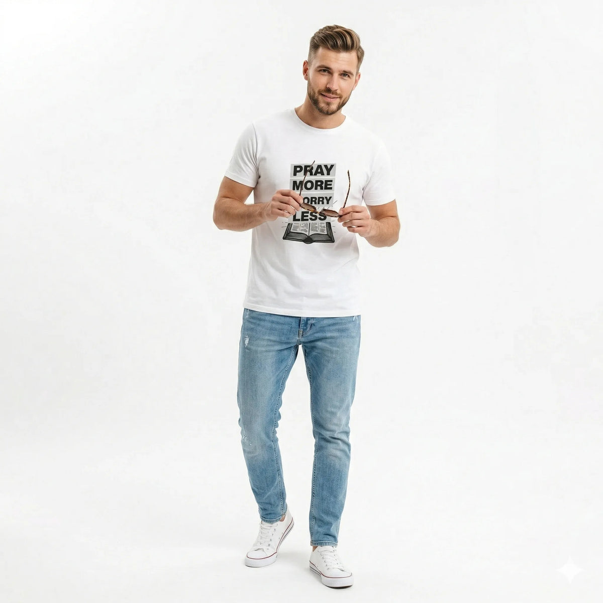 Man wearing a white t-shirt with text and light blue jeans on a white background