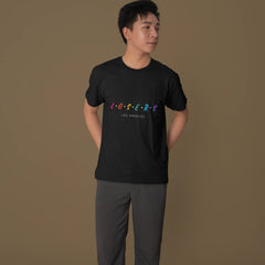 Person wearing a black t-shirt with colorful text on a brown background