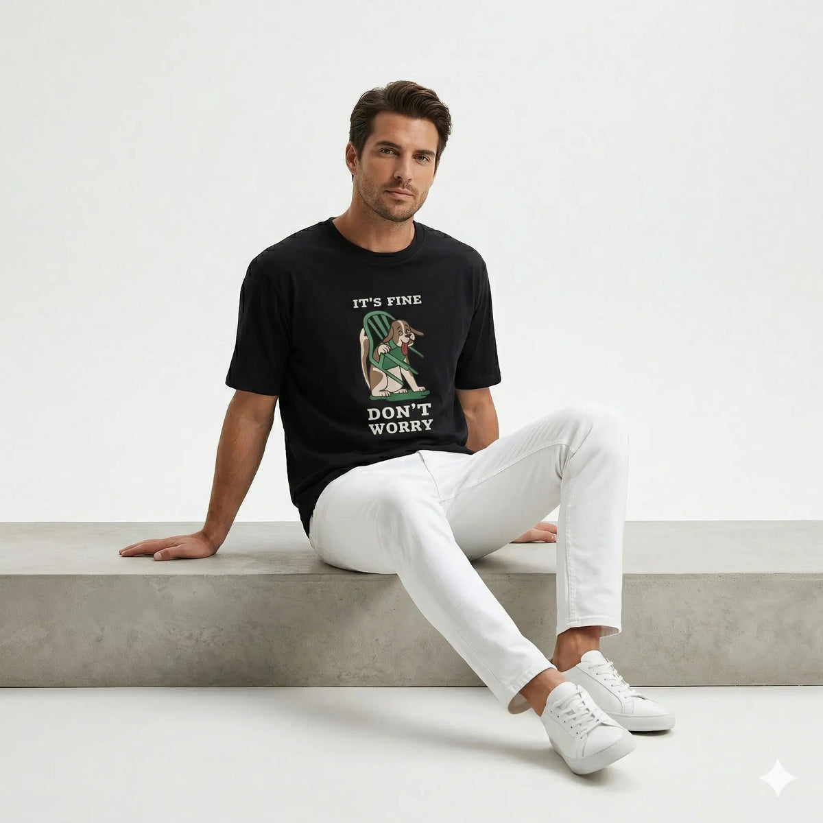 Man wearing a black t-shirt with a graphic design sitting on a concrete bench.