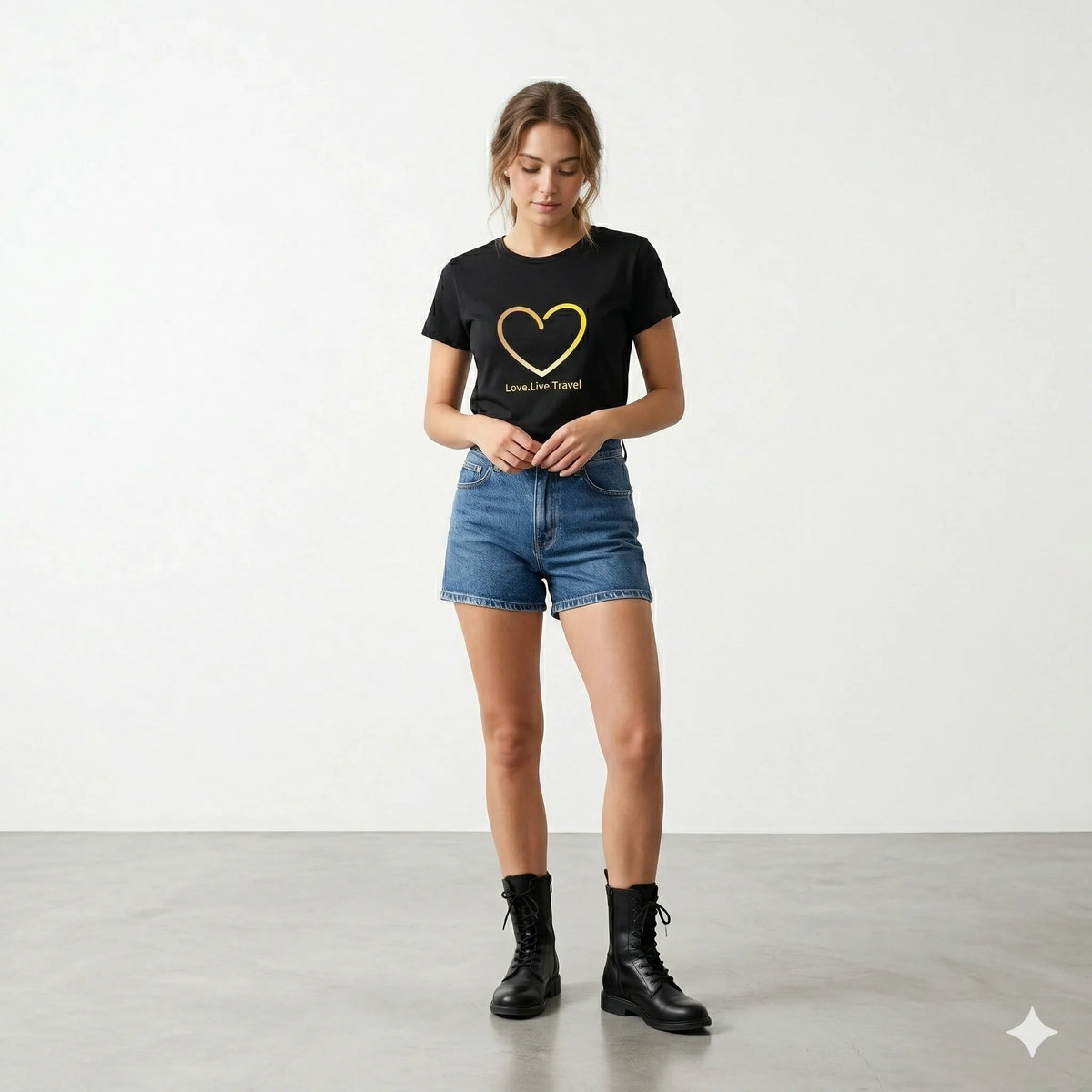 Woman holding a coffee cup wearing a black t-shirt with a heart design and text.