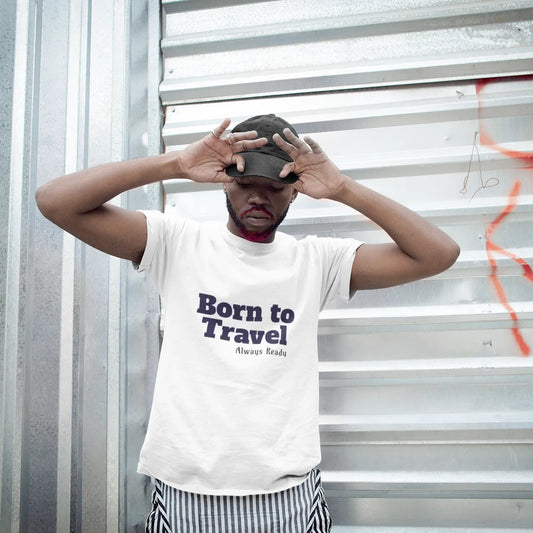 Person wearing a 'Born to Travel' t-shirt against a metal wall with graffiti.
