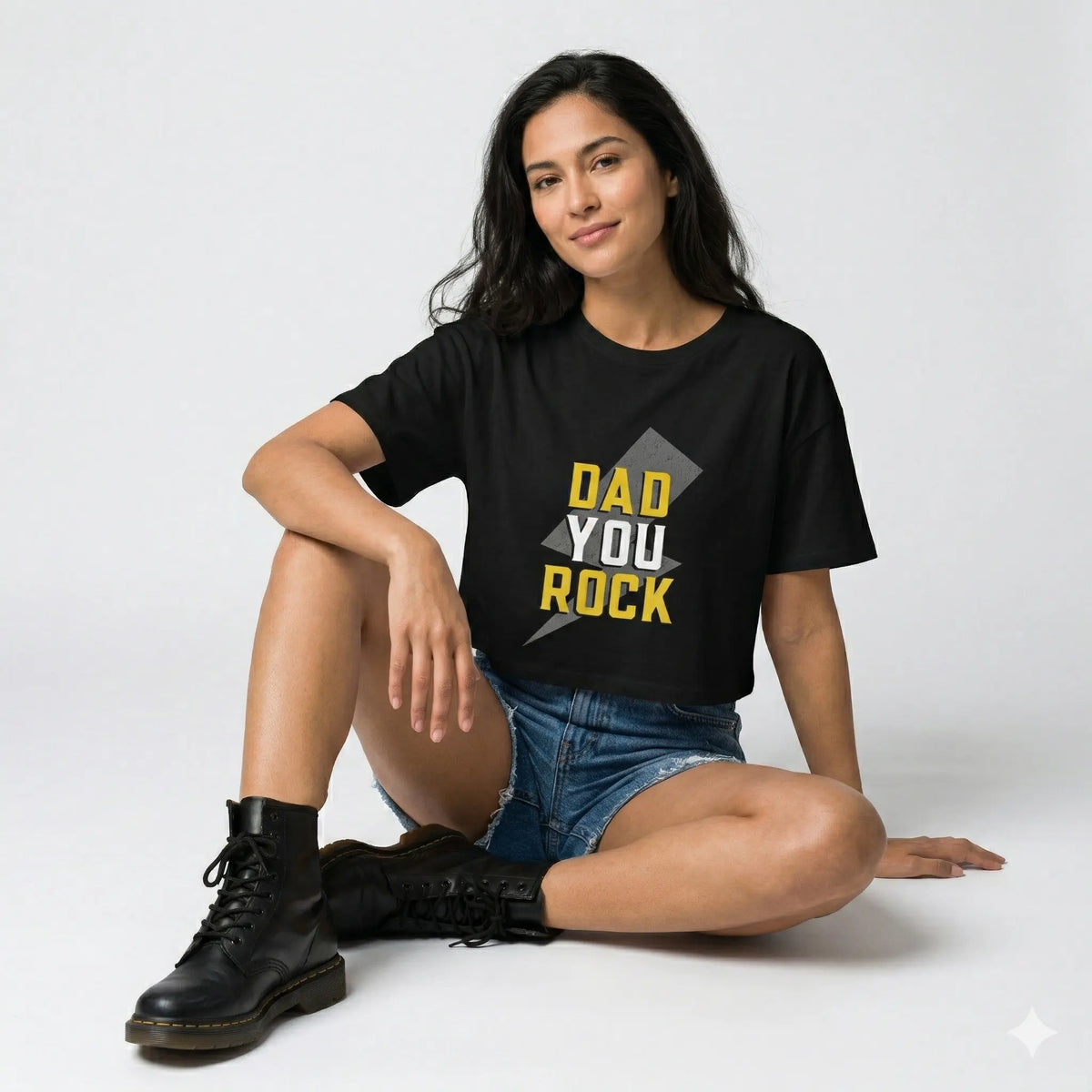 Woman wearing a black t-shirt with 'DAD YOU ROCK' text, standing outdoors.