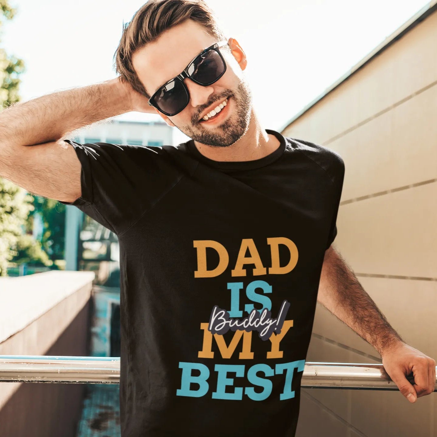 Man wearing a black t-shirt with 'DAD IS MY BEST' text, standing outdoors.