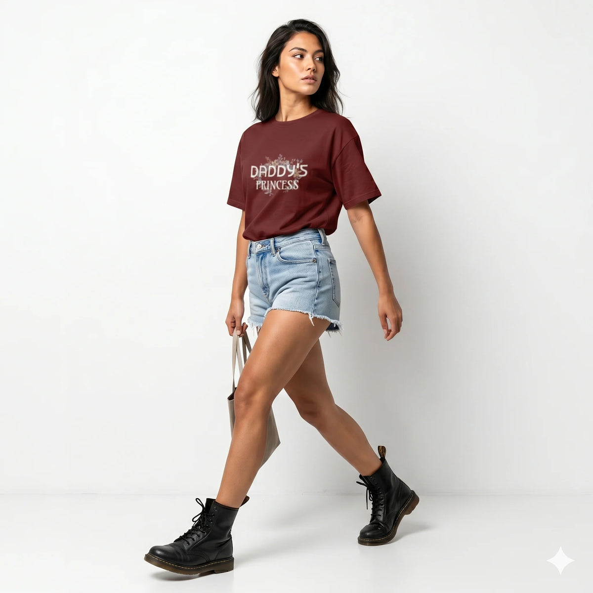 Woman wearing a maroon t-shirt with 'Daddy's Princess' text, denim shorts, and black boots on a white background