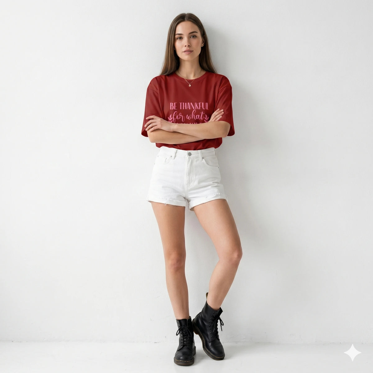 Woman wearing a red t-shirt with text and white shorts on a plain background