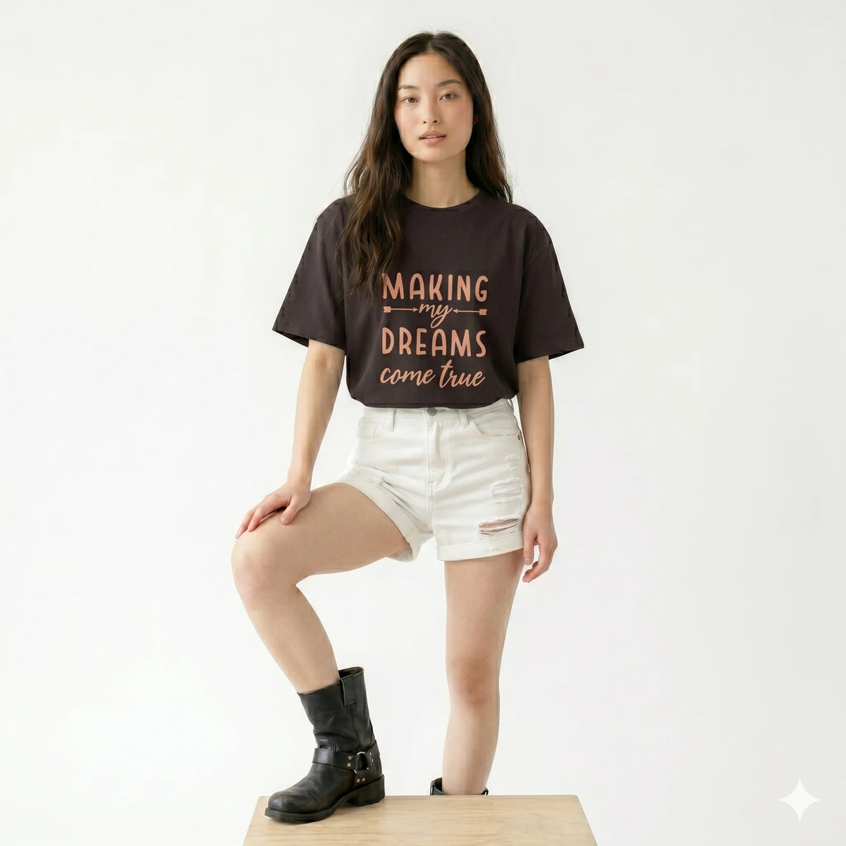 Person wearing a black t-shirt with text and white shorts on a white background