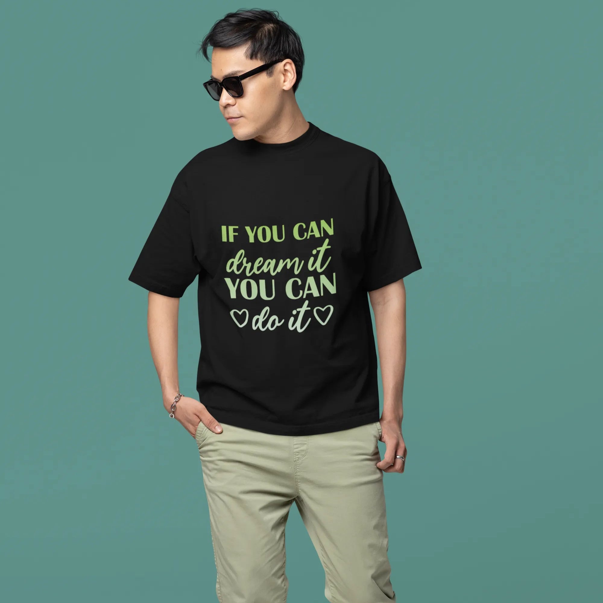 Man wearing a black t-shirt with motivational quote on a teal background