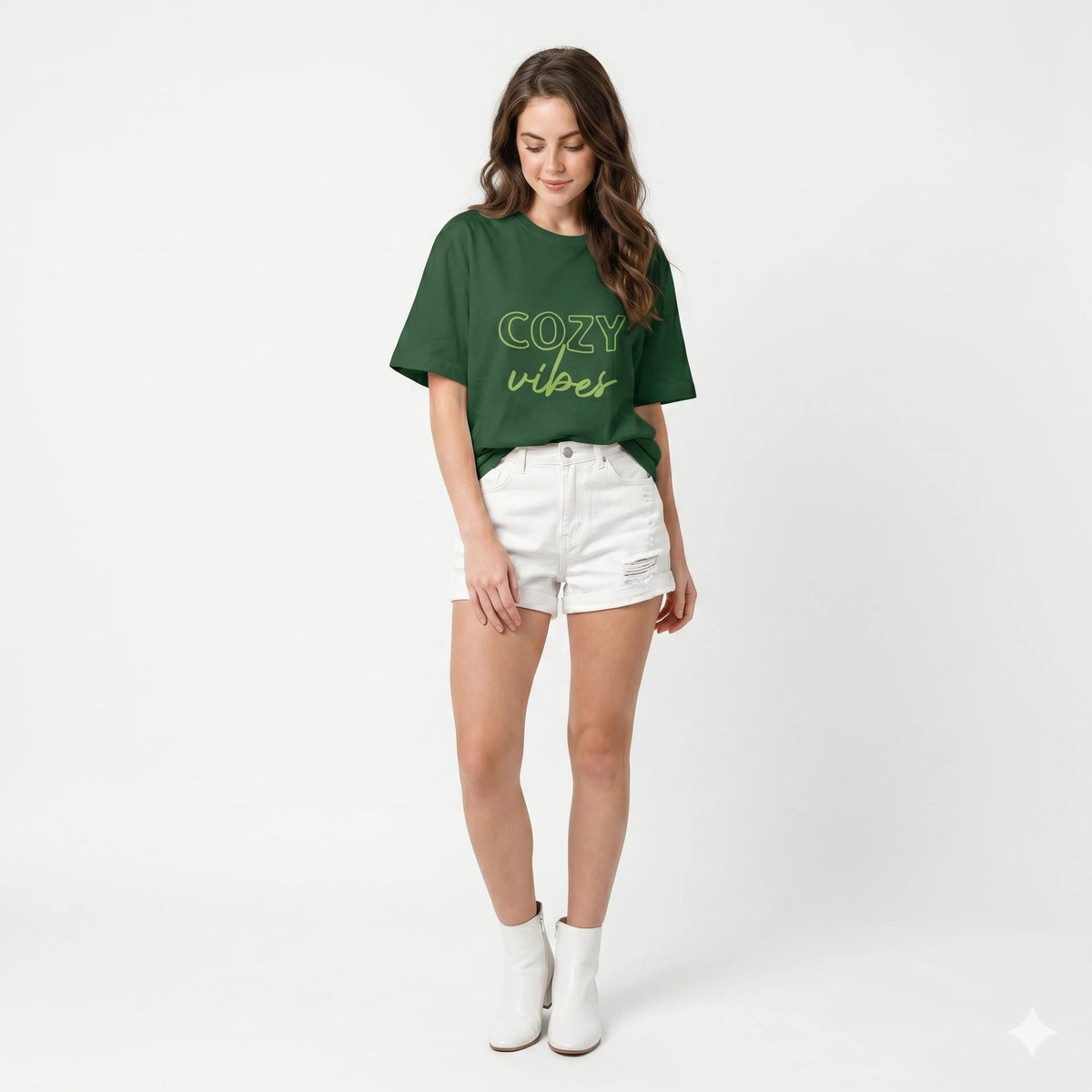 Person wearing a green 'cozy vibes' t-shirt with arms raised outdoors.