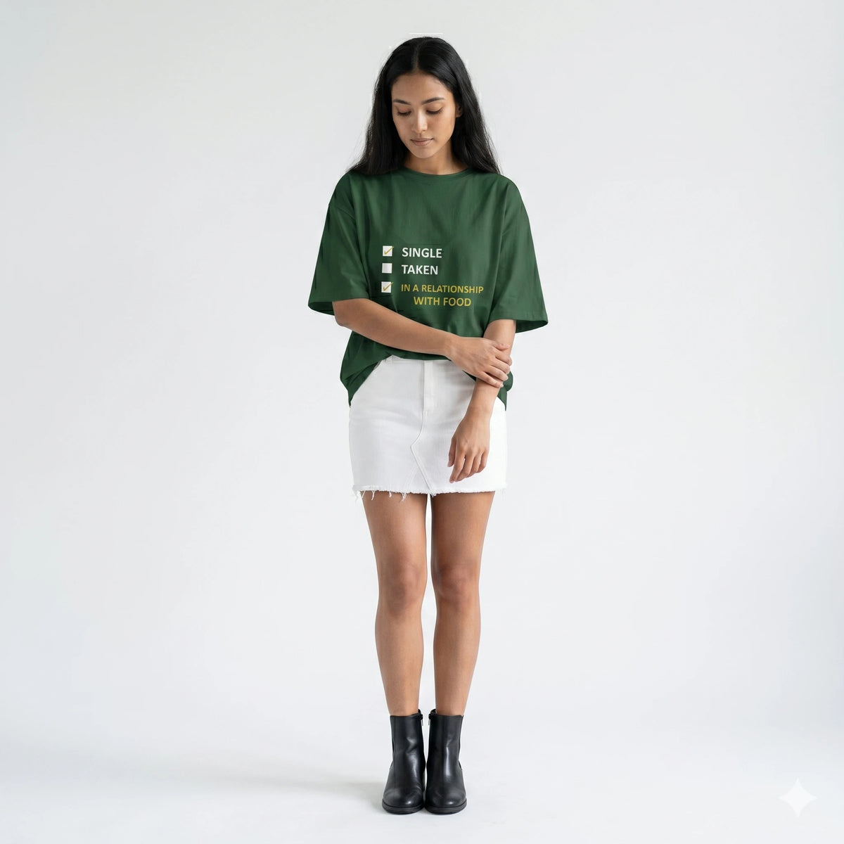 Woman wearing a green t-shirt with text and a white skirt on a white background