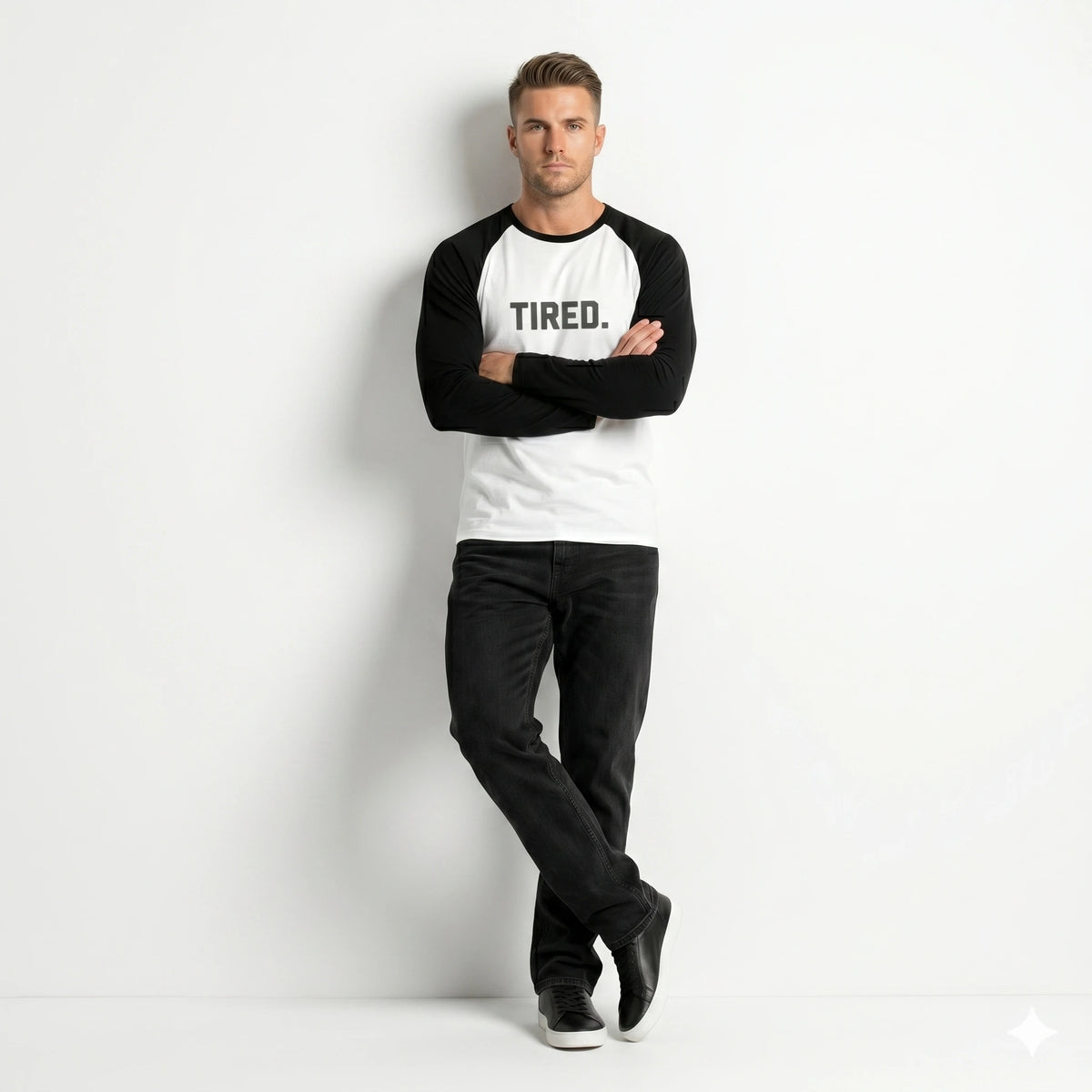 Man wearing a black and white long-sleeve shirt with 'TIRED.' text on a white background