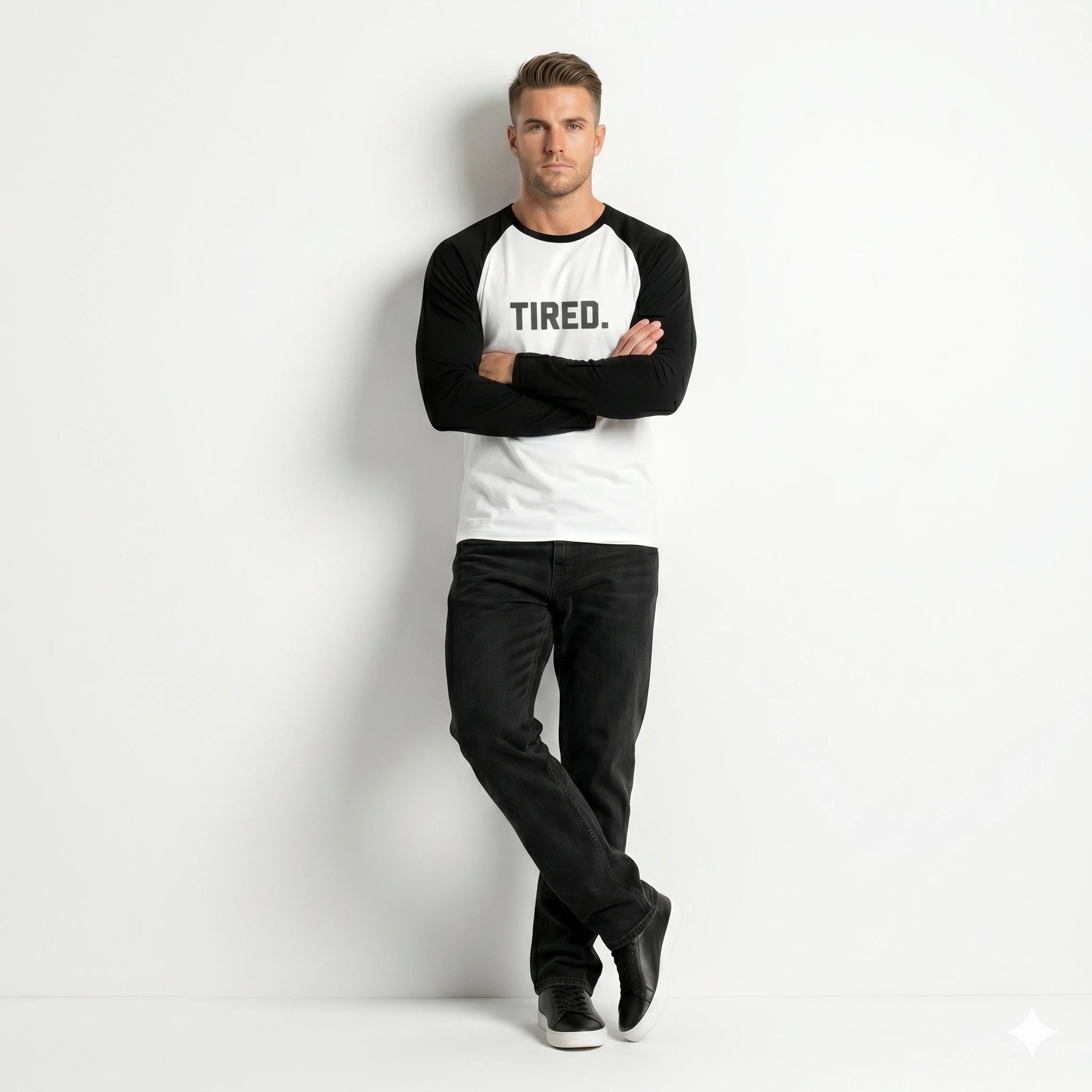 Man wearing a black and white long-sleeve shirt with 'TIRED.' text on a white background
