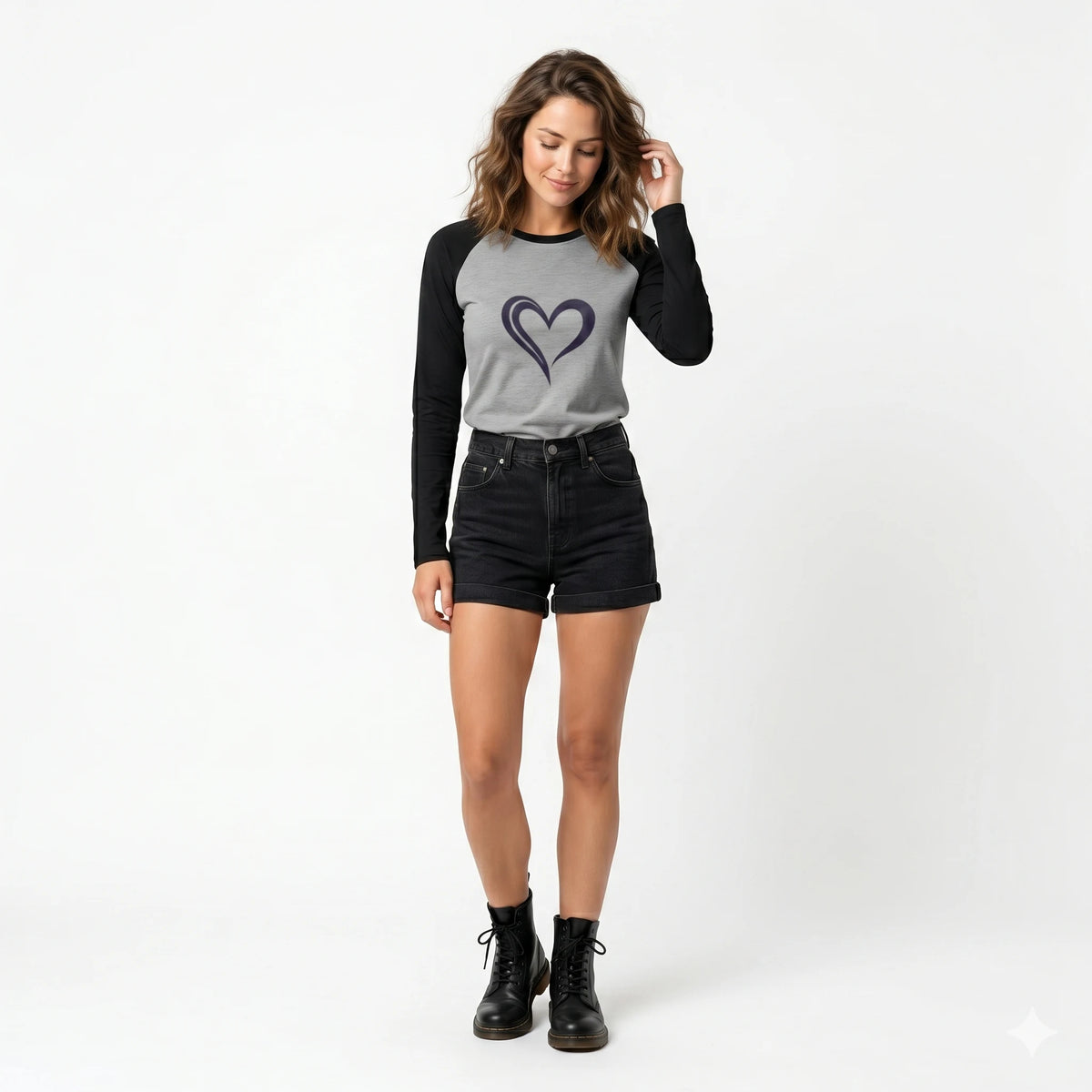 Woman wearing a gray long-sleeve shirt with a heart design and black shorts on a white background