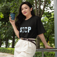 Woman holding a coffee cup outdoors with greenery in the background