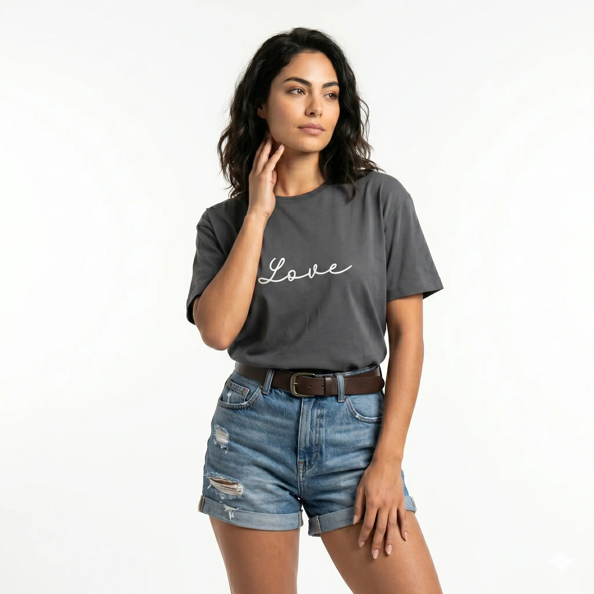Woman wearing a gray t-shirt with 'love' printed on it and denim shorts.