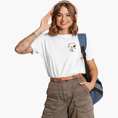Woman wearing a white t-shirt with a graphic design, brown cargo pants, and pink headphones on a white background.