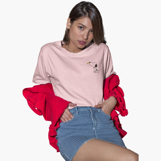 Woman wearing a pink oversized shirt with a graphic, blue shorts, and a red jacket on a white background