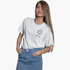 Person wearing a white t-shirt with a small graphic design on a plain background