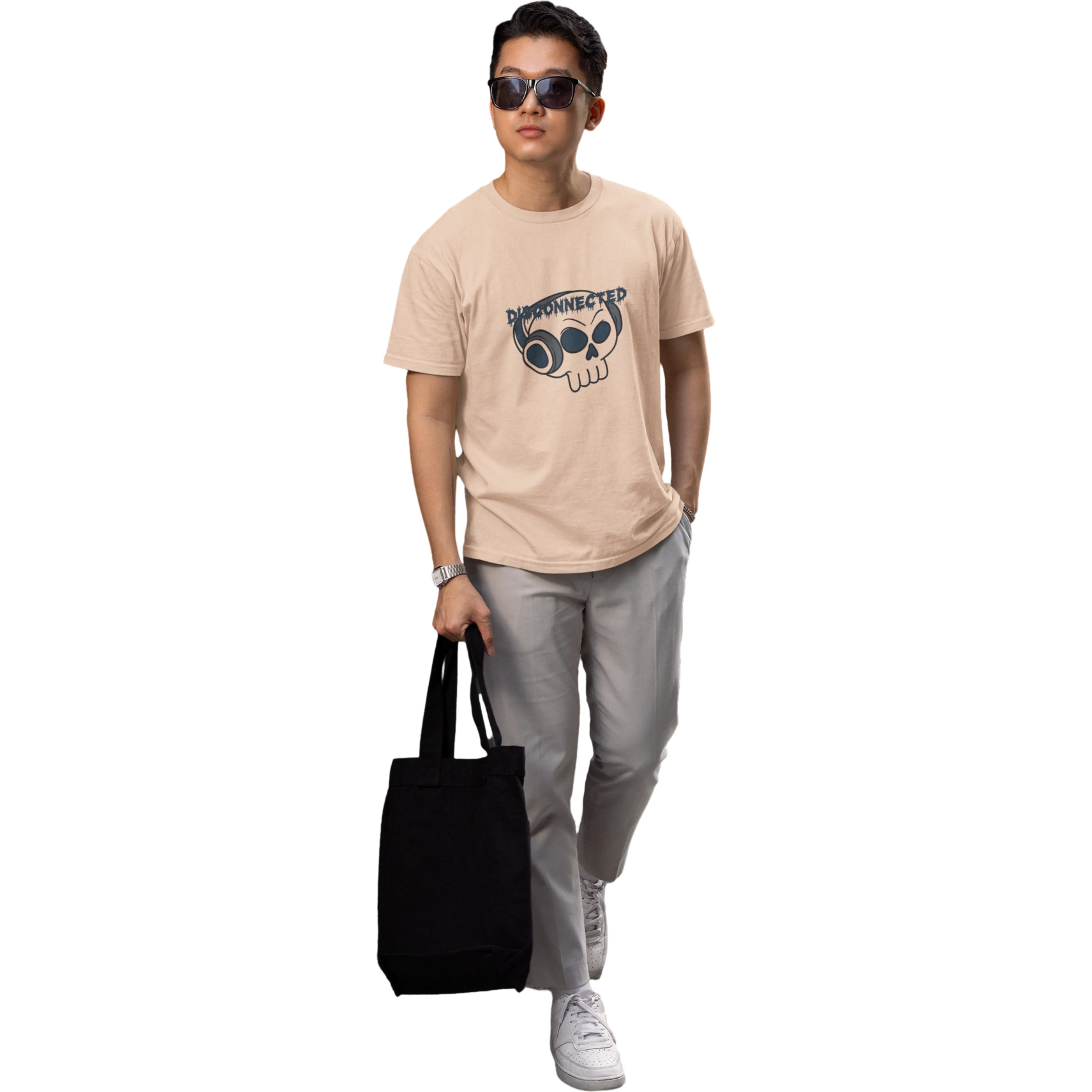 Person wearing a beige t-shirt with a graphic design, holding a black tote bag on a white background
