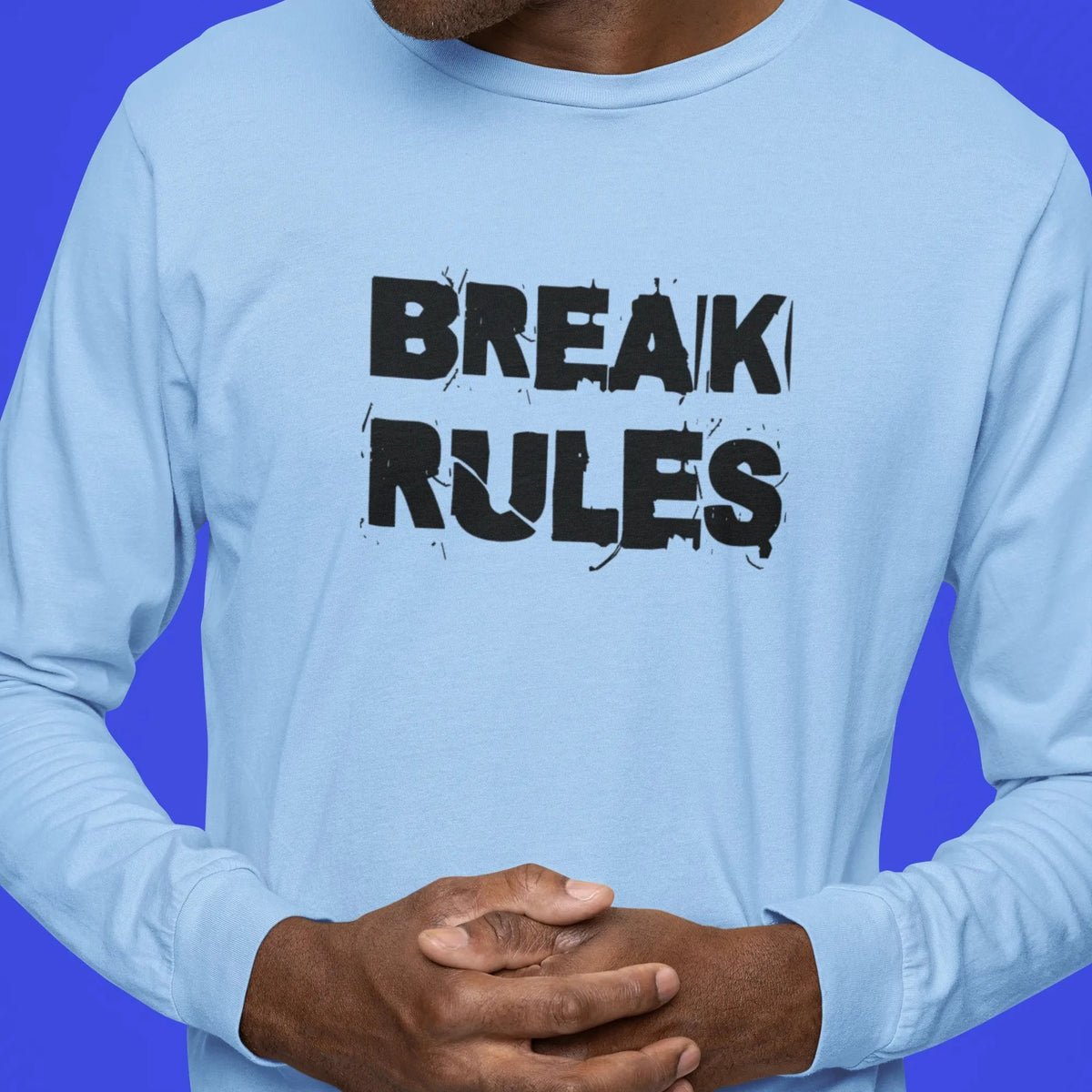 Man wearing a light blue long-sleeve shirt with 'BREAK RULES' text on a blue background
